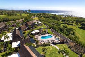 an aerial view of a resort with a swimming pool and the ocean at 54 Old Hawaii Charm Condo in Pahala