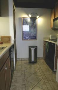 a kitchen with a trash can in the corner at 54 Old Hawaii Charm Condo in Pahala