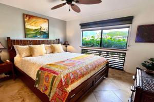 a bedroom with a bed and a window at 70 Pogs Place at Black Sand Beach in Pahala