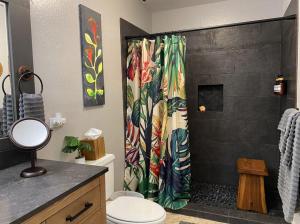 a bathroom with a shower with a colorful shower curtain at 70 Pogs Place at Black Sand Beach in Pahala