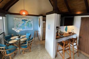 a kitchen and dining room with a table and chairs at 70 Pogs Place at Black Sand Beach in Pahala +25 photos