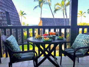 a table with a bowl of fruit on a balcony at 70 Pogs Place at Black Sand Beach in Pahala