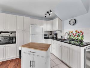a kitchen with white cabinets and a clock on the wall at 57 Beautiful Remodeled Studio in Pahala +8 photos