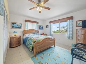 a bedroom with a bed and a ceiling fan at Honu Harbor with Pool on Golf Course in Naalehu +22 photos