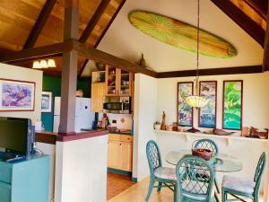 a kitchen with a table and chairs and a surfboard on the ceiling at Unit 26 King Bed and Ocean View in Pahala
