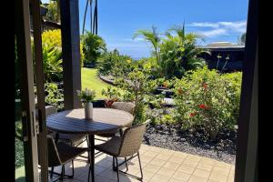 a table and chairs on a patio with a view of a garden at Unit 05 Well Maintained Studio in Pahala