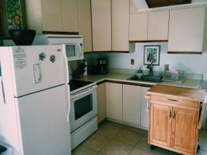 a kitchen with a white refrigerator and a sink at Unit 25 Hula Hut Best Value in Pahala