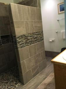 a bathroom with a tiled shower with a sink at Unit 25 Hula Hut Best Value in Pahala +10 photos