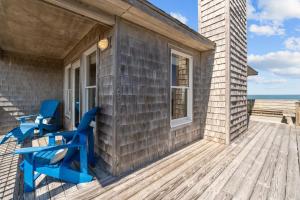 a deck with two blue chairs on it at 2410 - Come Sail Away in Duck