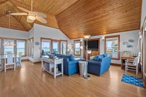 a living room with blue furniture and a wooden ceiling at 2410 - Come Sail Away in Duck +39 photos