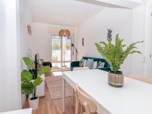 a living room with a white table and plants at Akisol Olhão Sweet in Olhão