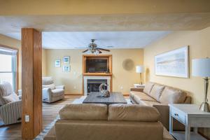 a living room with a couch and a fireplace at 5195 - Captain's Choice in Kill Devil Hills