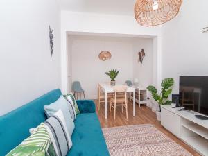 a living room with a blue couch and a table at Akisol Olhão Sweet in Olhão
