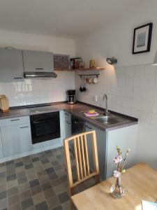 a kitchen with a sink and a table with a chair at Landhaus-Sutje-Deichblick in Böhl