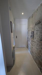 a hallway with a stone wall and a white door at Les Misstinguettes in Hyenville +9 photos