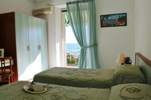 1 dormitorio con 2 camas y ventana en Appartamenti Mare Azzurro by Holiday World, en Albisola Superiore
