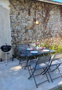 a black table with chairs and a grill with flowers on it at Les Misstinguettes in Hyenville