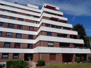 an apartment building with red and white balconies at Elbe Ferienwohnung Glückstadt in Glückstadt