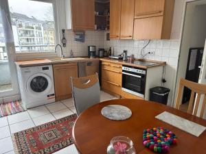 a kitchen with a table and a sink and a dishwasher at your accomodation in Aachen in Aachen +4 photos