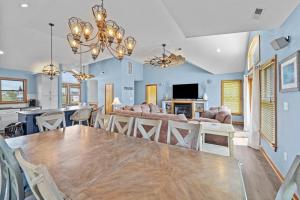 a dining room and living room with a wooden table at 1090 - Catch Me N Corolla in Corolla +51 photos