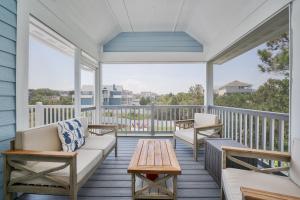 a porch with a couch and a coffee table at 4918 - Stress Less in Kitty Hawk