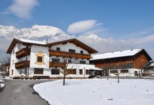 ein Haus im Schnee mit einem Berg im Hintergrund in der Unterkunft Gästehaus Sonnweber in Mieming