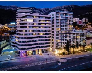 a large building with lights on in a city at Green Stone lamela B in Rafailovici
