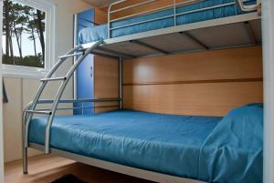 a bedroom with two bunk beds and a window at Parque de Campismo Orbitur Valverde in Luz +32 photos