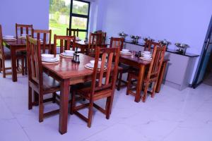 a wooden table and chairs with plates and dishes on it at De Lux Villa in Bulawayo