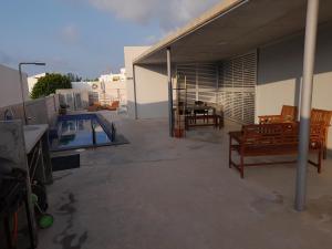 a patio with two benches and a swimming pool at La CASA GRIS in Alcanar
