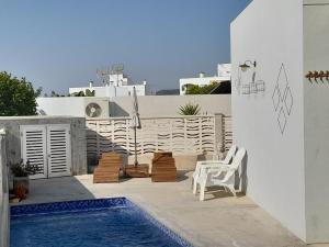 a patio with a swimming pool and a table and chairs at La CASA GRIS in Alcanar