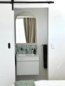 a bathroom with a mirror and a sink at Mountain View Studio Hermanus in Hermanus