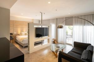 ein Schlafzimmer mit einem Bett und einem Fernseher in einem Zimmer in der Unterkunft The Hub Urban Hotel in Asunción