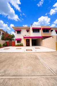 a house with pink and purple windows and a driveway at Haven Villa Retreat Jacuzzi Oasis in Mata los Indios