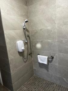 a shower stall with a towel dispenser in a bathroom at Tully Mill Cottages in Bellanaleck