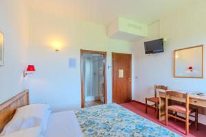 a bedroom with a bed and a desk with a computer at B&B La Bufalona - Pool & Relax in Massa Marittima
