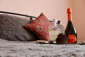 a bottle of wine on a bed next to a pillow at Arcadia di Vito in Tripoli
