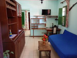 a living room with a blue bed and a table at Casa na cidade ITAPARICA Bahia House in ITAPARICA town in Itaparica