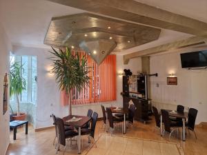 a dining room with tables and chairs and a tv at Casa Nobilă in Bran