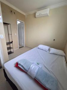 a bedroom with a white bed with a towel on it at Hostel Araguaia in Goiânia +20 photos