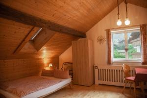 a bedroom with a bed in a attic with a window at Landhaus Thanner in Ofterschwang