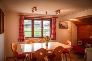 a dining room with a wooden table and chairs at Landhaus Thanner in Ofterschwang