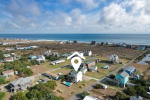 an aerial view of a small town with a large house at 7030 - Waves Against the Machine in Rodanthe