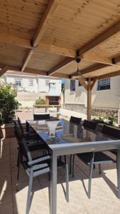 a patio with a table and chairs under a wooden roof at Casa Noel in Ciudad Quesada