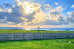 a fence on the beach with the ocean in the background at Cliff Top Accommodation in Spanish Point +19 photos