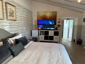 a bedroom with a bed and a flat screen tv at Casa Santo Antonio in Pias