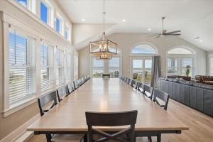 a dining room with a long table and chairs at 5700 - La Cebolla in Nags Head