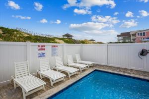 a group of chairs sitting next to a swimming pool at 5700 - La Cebolla in Nags Head