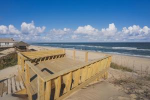 a wooden bench on the beach near the ocean at 5700 - La Cebolla in Nags Head +84 photos