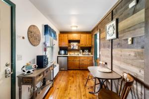 a kitchen with wooden floors and a table and a dining room at Private Mountain Nook with Jacuzzi - Cabin 6 in Fancy Gap